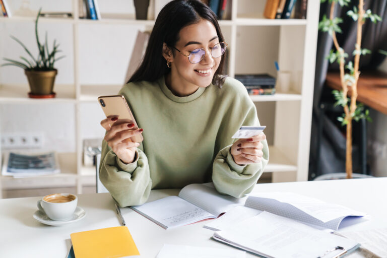 Happy optimistic young girl student holding credit